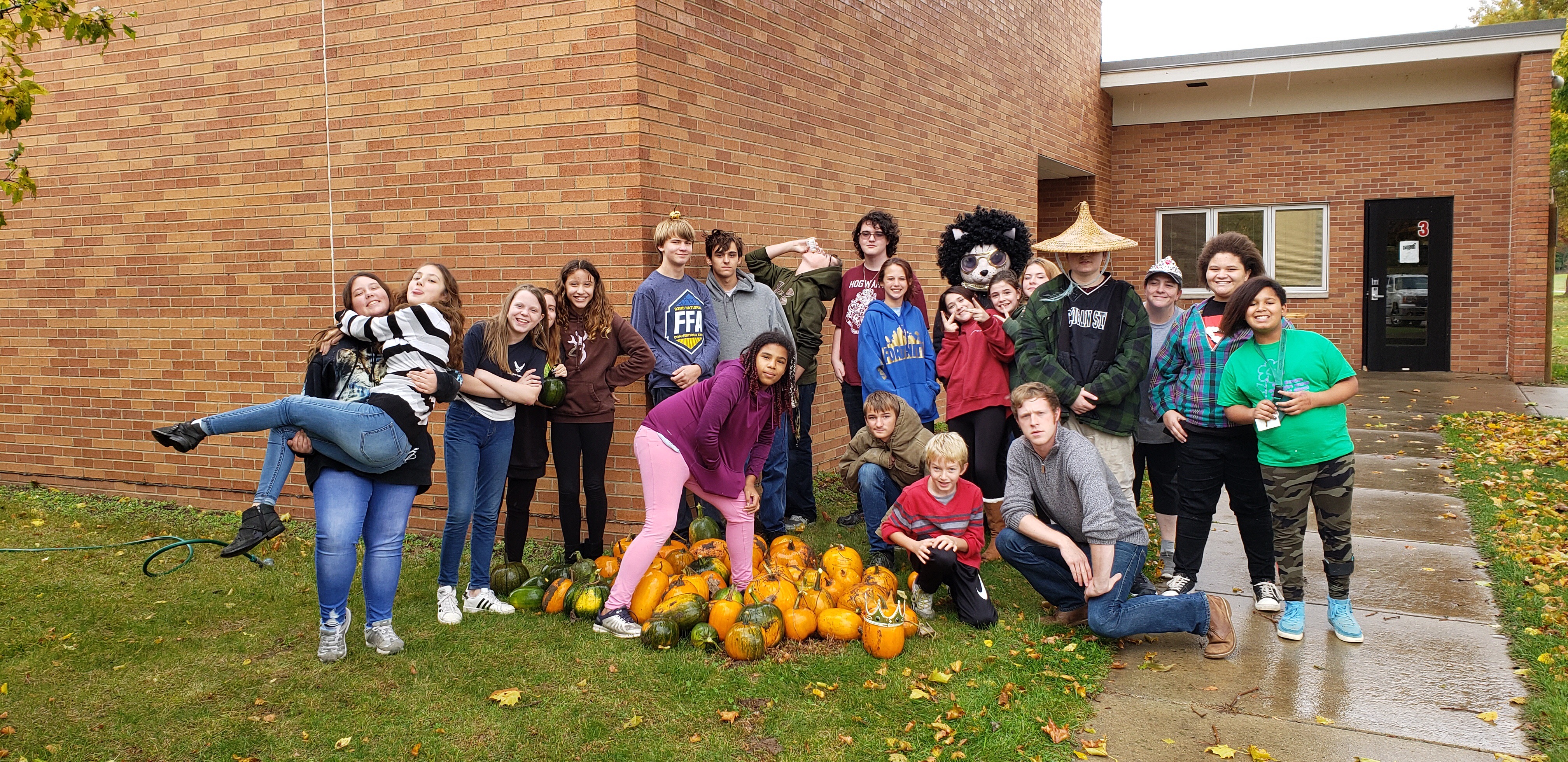 Photo of teens posing with pumpkins outside the Eaton Rapids Teen Space.